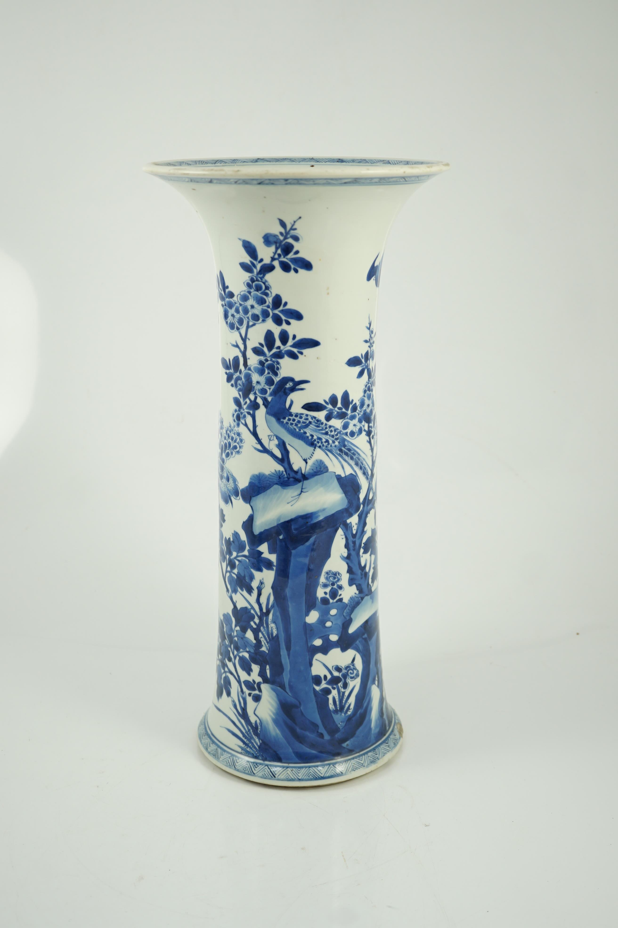 A tall Chinese blue and white ‘pheasants and rocks’ beaker vase, gu, Kangxi period, minor faults